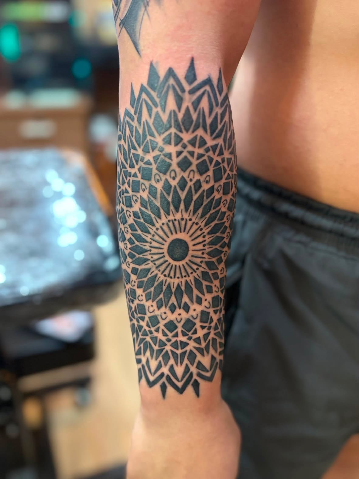 Geometric mandala forearm tattoo